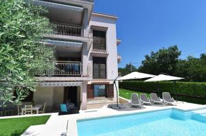 a villa with a swimming pool in front of a house at Villa Maravilla in Jadranovo