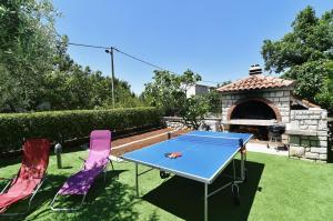 a ping pong table and two chairs in a yard at Villa Maravilla in Jadranovo