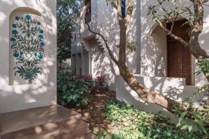 a house with a wall with a tree painted on it at Le Casa Lion Resort A Premium Resort In Sasan Gir in Sasan Gir
