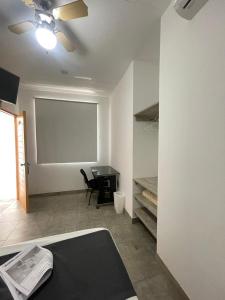 a room with a desk and a ceiling fan at Golden Suite Miraflores 