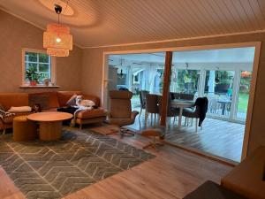 a living room with a couch and a table at Beautiful and private with heated pool & hot tub in Ljungbyhed