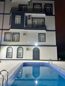 a building with a swimming pool in front of a house at Marison Hotel Baku in Baku