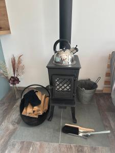 a black stove with a tea kettle on top at Relax House Mšené-lázně in Loucká