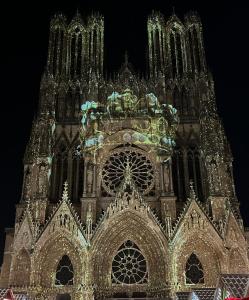 a large building with a clock tower at night at Wellness Suite Ponsardin RDC - Reims Centre in Reims