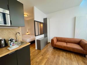 a kitchen with a couch and a bed in a room at Wellness Suite Ponsardin RDC - Reims Centre in Reims