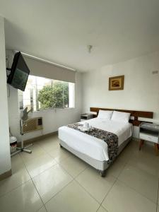 a bedroom with a bed and a flat screen tv at Golden Suite Miraflores 