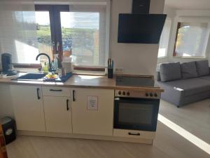 una cocina con estufa horno de arriba junto a un sofá en Ferienwohnung Familie Aestel, en Altensteig