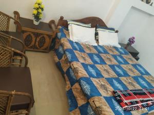1 cama con edredón y almohadas azules en Globalindia Homestay, en Guwahati 5 fotos más