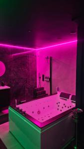 een roze badkamer met een groot bad in een kamer bij Love room - Xtase By luxuria Cannes in Cannes