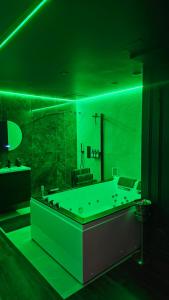 een groene badkamer met een bad en een wastafel bij Love room - Xtase By luxuria Cannes in Cannes +10 foto's