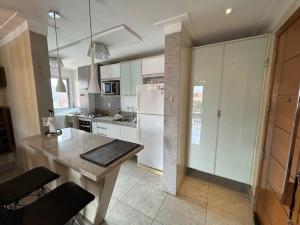 a kitchen with white cabinets and a table in it at COP 30 aconchego e conforto in Ananindeua