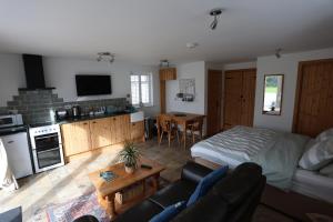 a living room with a bed and a kitchen with a couch at Lynton Lodge Studios in Keswick