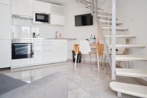 a kitchen with white cabinets and a table with chairs at Las Tortugas Bungalow Beach in Arona