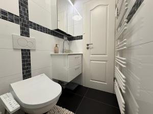 ein weißes Badezimmer mit Toilette und Waschbecken in der Unterkunft Premium Yacht Ausstattung Apartments Hotel 3 in Hamburg + 10 Fotos