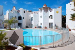 a villa with a swimming pool in front of a building at Las Tortugas Bungalow Beach in Arona
