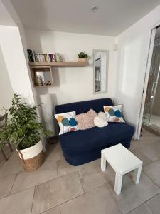 een woonkamer met een blauwe bank en een tafel bij Two rooms with 30 m2 garden in villa in Cagnes-sur-Mer