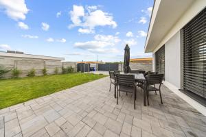 d'une terrasse avec une table, des chaises et une cour. dans l'établissement Klimatizovaný Apartmánový dom s vírivkou, 9B, à Jánošíková