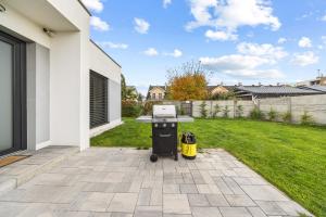 - un barbecue dans l'arrière-cour d'une maison dans l'établissement Klimatizovaný Apartmánový dom s vírivkou, 9B, à Jánošíková