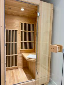 a wooden sauna with a glass door in a room at Wellness Suite Ponsardin 1 - Reims Centre in Reims