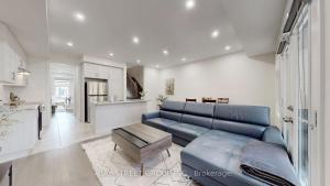 een woonkamer met een blauwe bank en een keuken bij Modern in Richmond Hill in Richmond Hill