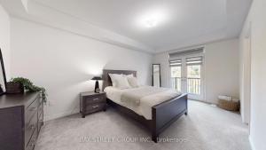 een witte slaapkamer met een bed en een raam bij Modern in Richmond Hill in Richmond Hill