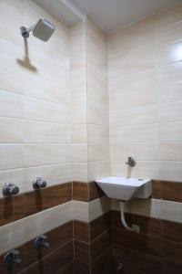 a bathroom with a sink and a shower at Hotel Aasopalav in Ahmedabad