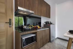 eine Küche mit Spüle und Mikrowelle in der Unterkunft Pool Access 1 Bedroom Duplex UTL A107 near Nai Harn Beach in Rawai Beach