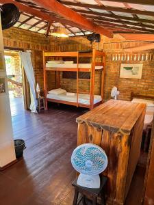 Una habitación con literas y una mesa de madera. en Hostel do Ceu, en Pipa
