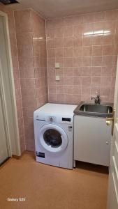 ストックホルムにあるCozy house in peaceful location with close access to amenitiesの洗面台付きの浴室にある洗濯機
