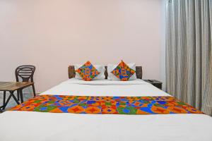 a bedroom with a bed with a colorful comforter at FabHotel AI Howrah in Kolkata +19 photos