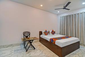 コルカタにあるFabHotel AI Howrahのベッドと椅子とテーブルのある寝室