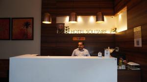 a man sitting at a counter in a restaurant at Hotel LOTO Premier Vijay Nagar in Jāmb