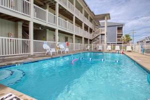una piscina en un hotel con dos sillas en ella en BEAUTIFUL BEACHFRONT-Oceanfront First Floor 2BR 2BA Condo in Cherry Grove, North Myrtle Beach! RENOVATED with a Fully Equipped Kitchen, 3 Separate Beds, Pool, Private Patio & Steps to the Sand!, en Myrtle Beach