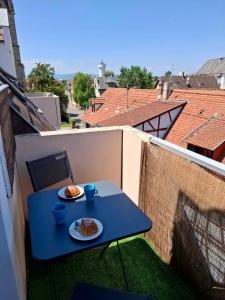 een blauwe tafel met twee borden met eten op een balkon bij Au Nichoir in Erstein