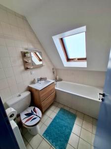 een badkamer met een bad, een toilet en een wastafel bij Au Nichoir in Erstein