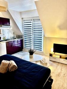 een slaapkamer met een bed, een tafel en een raam bij Au Nichoir in Erstein