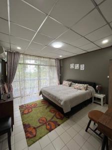 ein Schlafzimmer mit einem großen Bett und einem großen Fenster in der Unterkunft Cozy Beachside Retreat in Puek Tian, Thailand in Ban Tanot Noi