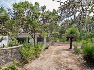 a dirt road with trees and a building at Wren Studio - Private One-Bedroom Studio Nestled in Bushland in Yallingup
