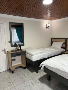 een kamer met 2 bedden, een spiegel en een tafel bij Sefaa Otel in Sultanahmet