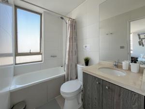 Un baño blanco con inodoro y lavabo. en Loica Host - Smart, en Santiago 49 fotos más