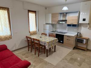 a kitchen with a table and chairs and a red couch at APPARTAMENTO MICKI 1 CAMERA e Soggiorno in Ventimiglia