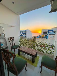 a living room with a bench and chairs and a balcony at Belle appartement a mahdia plage in Kenitra