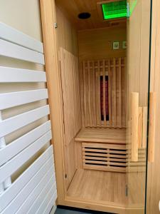 a sauna with wood paneling and a green light at Wellness Suite Ponsardin 2 - Reims Centre in Reims