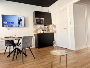 a kitchen with a table and chairs in a room at Wellness Suite Ponsardin 2 - Reims Centre in Reims