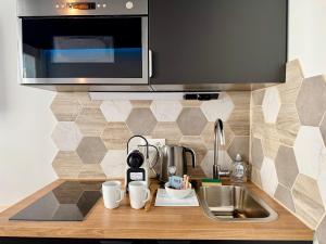 a kitchen counter with a sink and a microwave at Wellness Suite Ponsardin 2 - Reims Centre in Reims