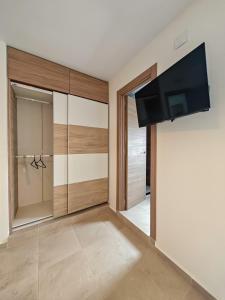 Una sala de estar con un televisor de pantalla plana en una pared. en Hostal Casa Miguel Marbella, en Marbella