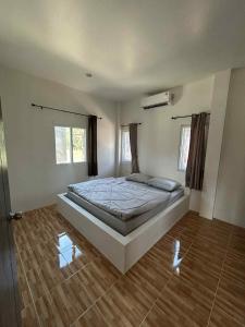 een slaapkamer met een groot bed in een kamer bij Wimanthara houses in Thongsala