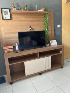 a flat screen tv on a wooden entertainment center at Portuga Flat - Olinda in Olinda