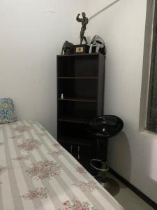 ein Schlafzimmer mit einem Bett und einem Hocker neben einem Regal in der Unterkunft Equipetrol departamento minino 2dias in Hamacas + 2 Fotos