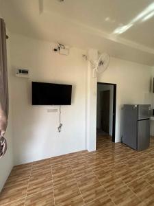 een woonkamer met een flatscreen-tv aan de muur bij Wimanthara houses in Thongsala